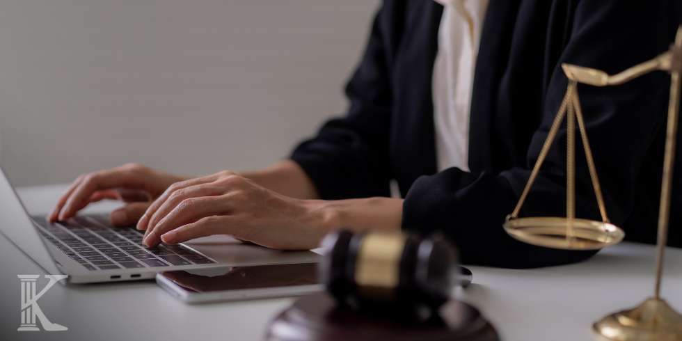 Złota waga i młotek sędziowski, prawnik piszący na laptopie