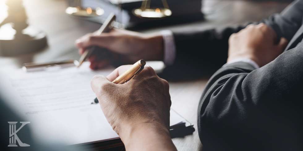 Dwie osoby w kancelarii prawnej, podpisywanie dokumentów, złota waga w tle