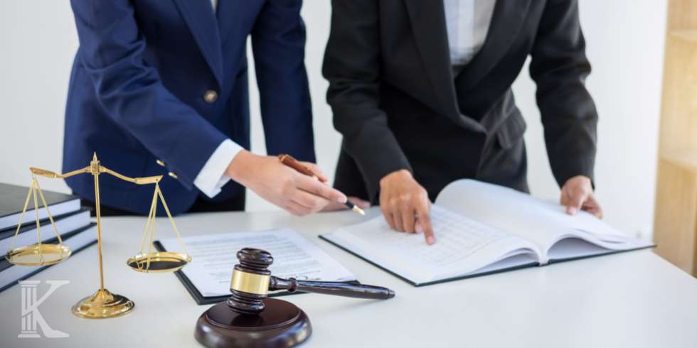 Dwie osoby w kancelarii prawnej, podpisywanie dokumentów, młotek sędziowski