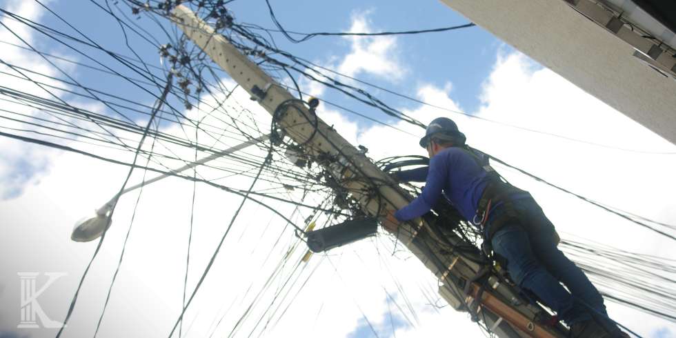 Słup wysokiego napięcia, pracownik przedsiębiorstwa przesyłowego