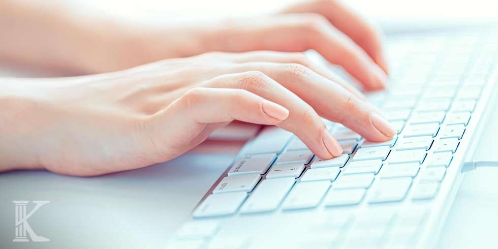 Dłonie piszące na klawiaturze laptopa