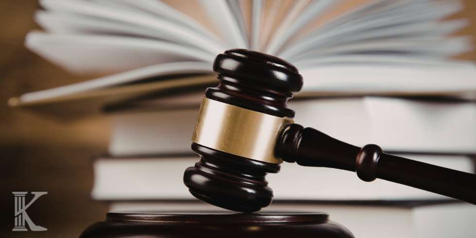 Judge's gavel resting on a sound block with blurred books in the background, conveying a legal or courtroom theme