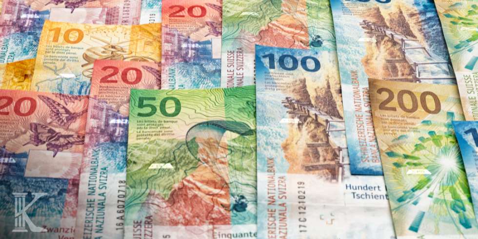 Colorful Swiss franc banknotes scattered and overlapping, showing denominations like 10, 20, 50, 100, and 200Thousands?