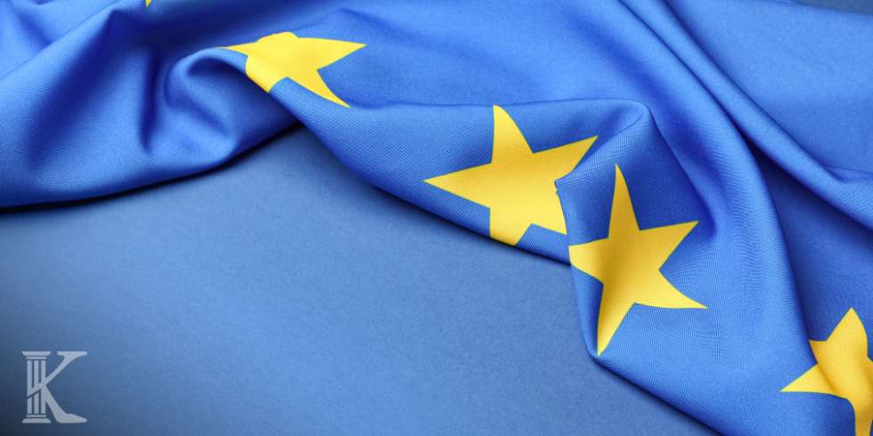 Blue fabric with yellow five-pointed stars suggesting the European Union flag, partially draped on a blue surface.