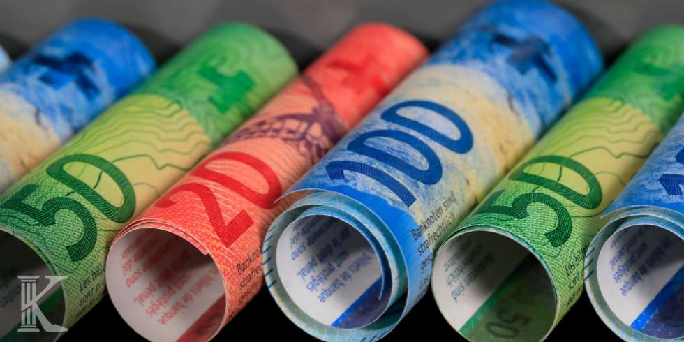 Rolled colorful Euro banknotes laid in a row, displaying denominations like 50, 20, and 100s.