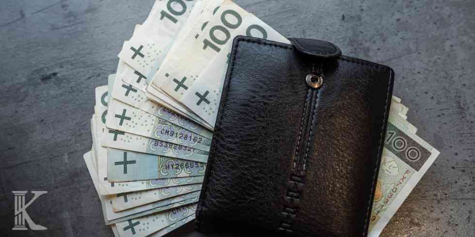 Portfel wypełniony polskimi banknotami jako symbol kwoty wolnej od potrąceń zostawionej przez syndyka.