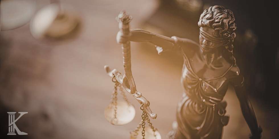 Statue of Lady Justice blindfolded, holding the scales to symbolize balanced, impartial justice.