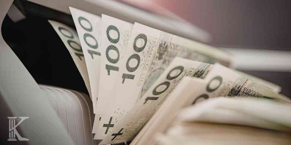 Liczarka odliczająca banknoty 100 zł jako symbol zwrotu odsetek i kosztów kredytu darmowego.