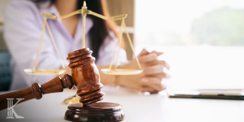Gavel resting on a desk with the scales of justice in the background, symbolizing law and fairness.