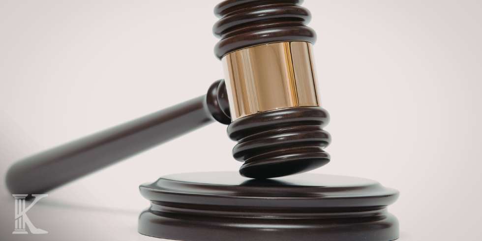Close-up of a wooden judge's gavel striking a sound block, symbolizing justice in a courtroom context